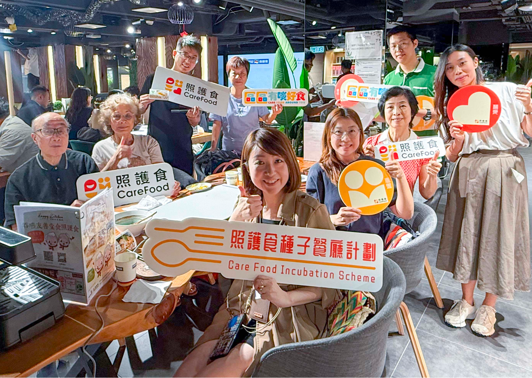 照護食種子餐廳計劃參加者於餐廳內舉牌合影